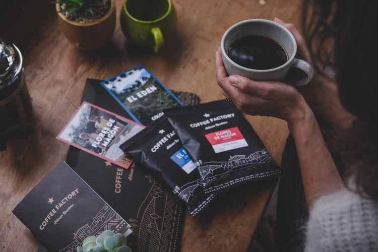 Selection of Roasters Club coffee subscription boxes with fresh whole bean and ground coffees, set on a wooden table