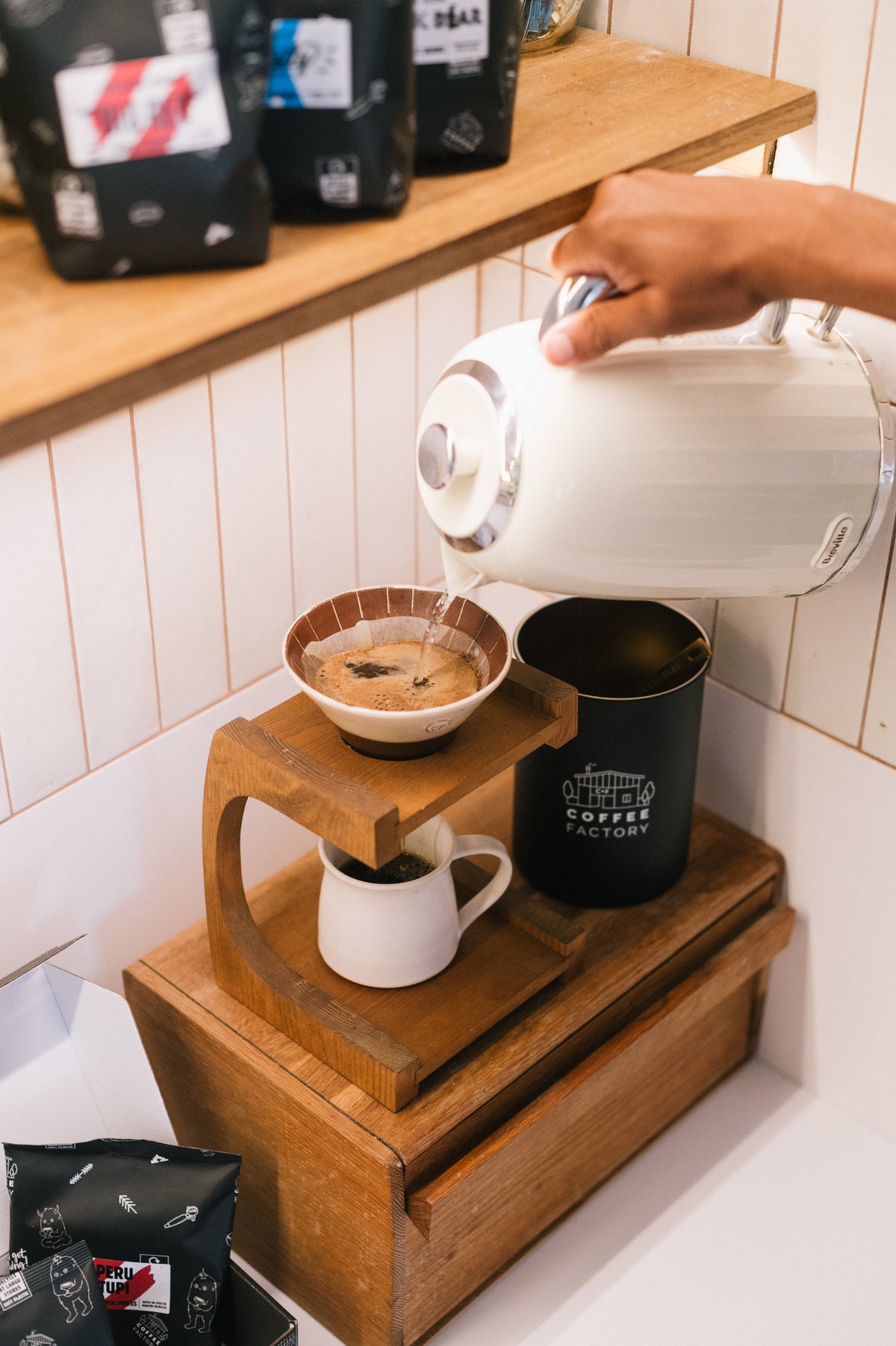 Pouring hot water into a pour-over coffee dripper with Coffee Factory beans